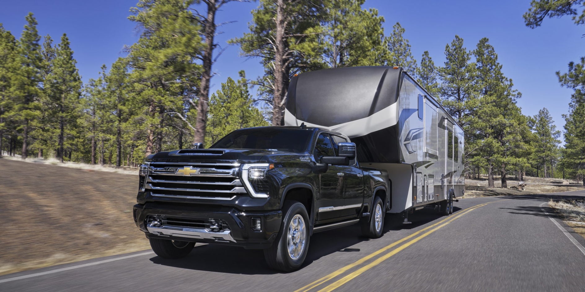 A black Chevy Silverado 2500 towing a trailer.