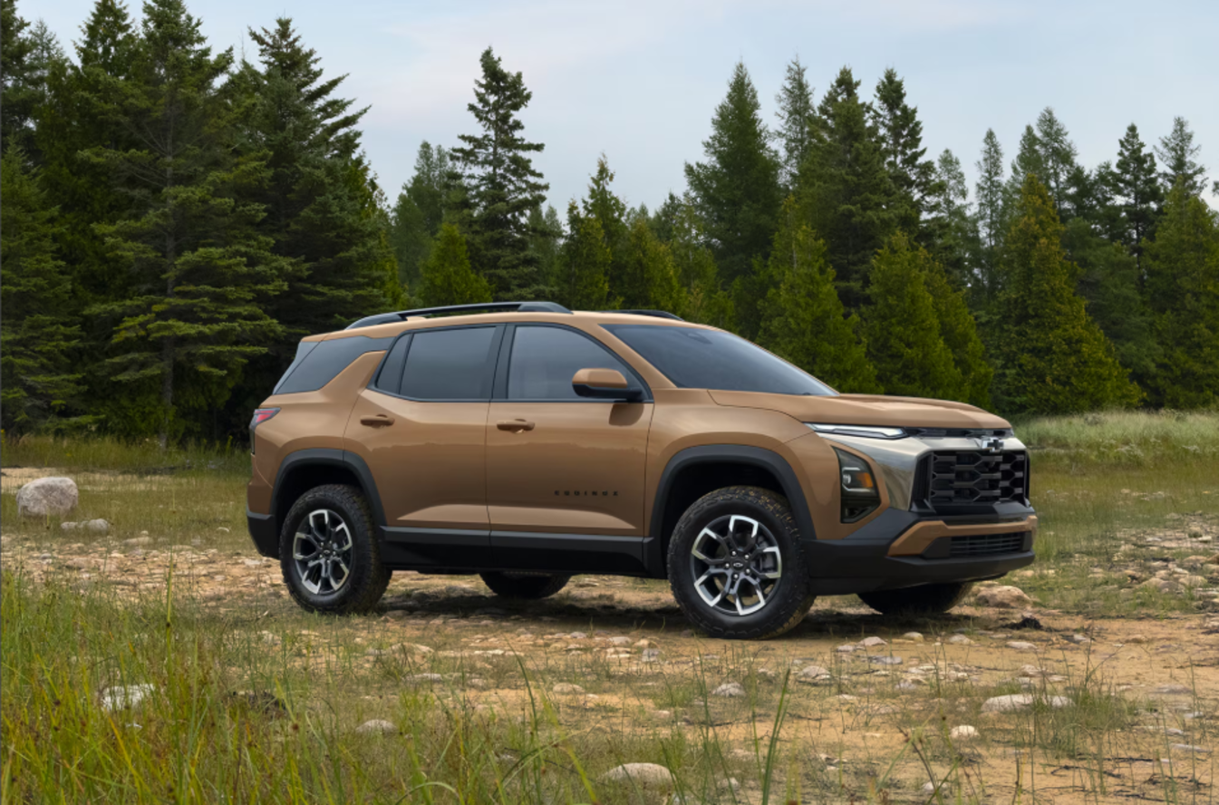 A brown Chevrolet Equinox on a dirt trail in a forest clearing.
